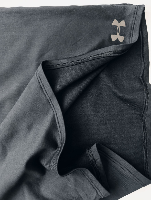 لباس ورزشی برند UNDER ARMOUR استوک اورجینال رنگ مشکی نمای نزدیک جنس پارچه
