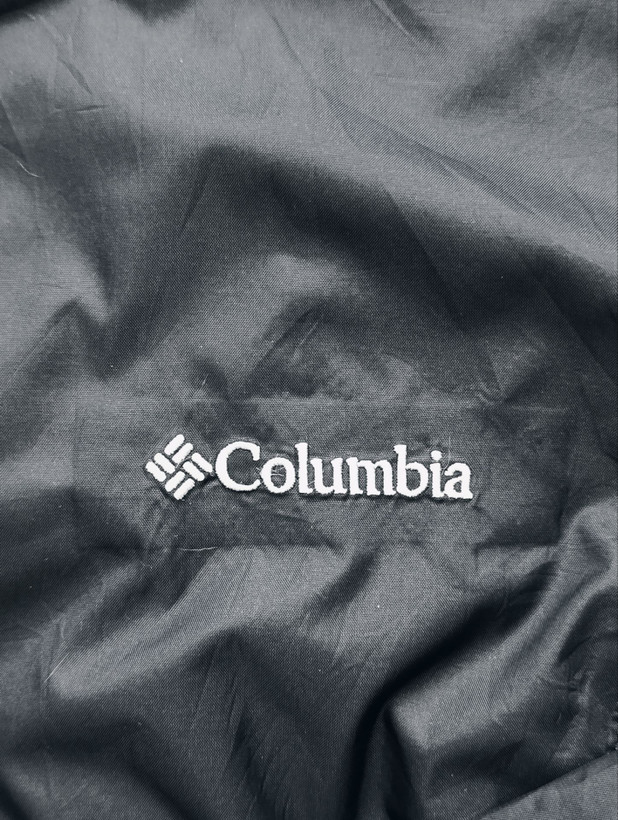 بادگیر زنانه برند COLUMBIA استوک اورجینال ضداب رنگ مشکی نمای برند روی محصول