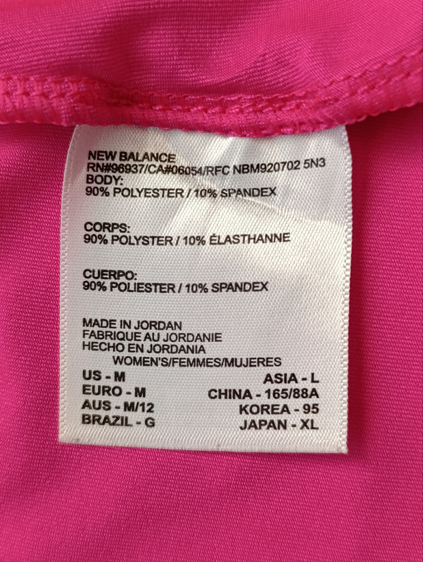 لباس ورزشی زنانه برند NEW BALANCE استوک اورجینال رنگ صورتی نمای اتیکت مشخصات