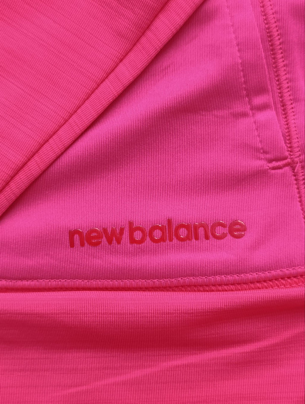 لباس ورزشی زنانه برند NEW BALANCE استوک اورجینال رنگ صورتی نمای برند روی لباس